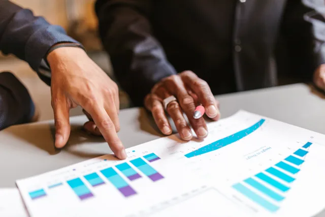 Business professionals analyzing charts and graphs during a meeting. What should affiliate marketing buyer personas include?