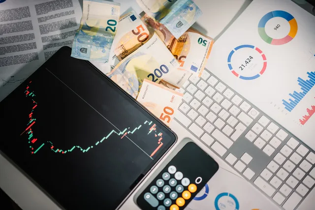 Overhead view of financial tools with Euro banknotes on a desk showing market trends and graphs. What do affiliate marketing costs and pricing look like for a UK brand?