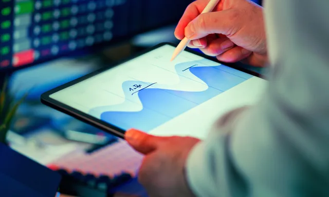 Professional analyzing data chart on a tablet with stylus in an office setting. Affiliate marketing for small businesses UK: weekly plan