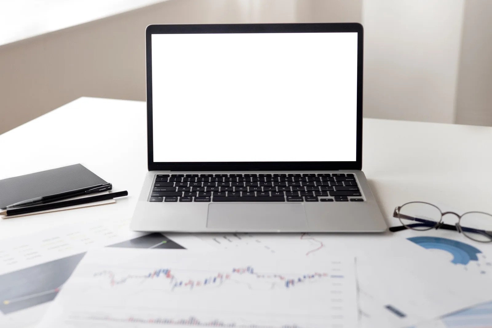 Open laptop with financial documents on a desk, ideal for business and technology themes.